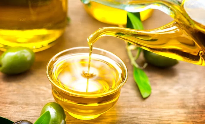 virgin olive oil pouring in a bowl close up