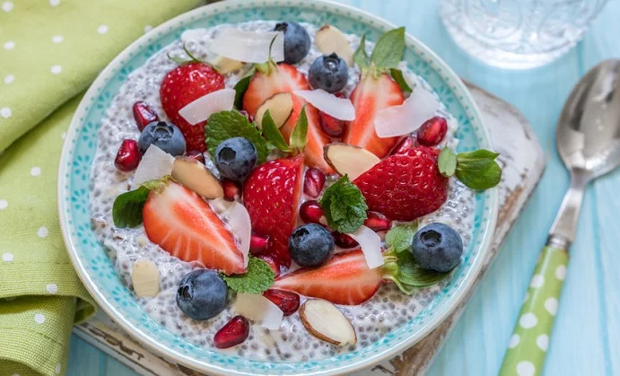 keto ketogenic, paleo low carb diet not oatmeal breakfast porridge. coconut chia pudding with berries, pomegranate seeds and almond